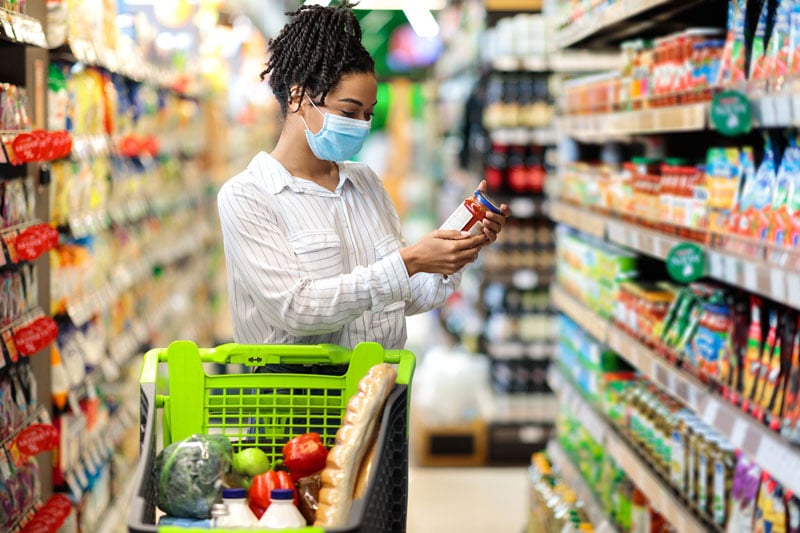 Woman holding food product doing grocery shopping